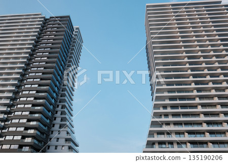 Modern high-rise skyscraper with repeating balconies against blue sky Modern high-rise skyscraper with repeating balconies against blue sky 135190206