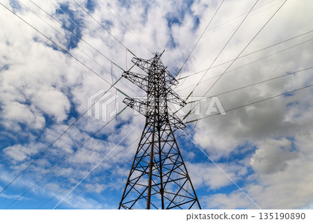 A striking power tower silhouette stands tall against a backdrop of a dramatic, cloudy sky 135190890