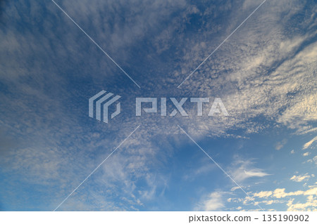 A tranquil sky adorned with wispy clouds and vibrant blue hues creates a serene atmosphere 135190902