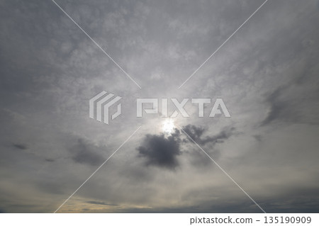 A Dramatic Cloudy Sky with Beautiful Sunlight Peeking Through the Overcast Environment 135190909