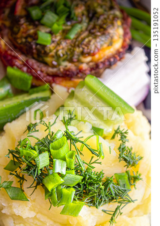 Baked meat with cheese and mashed potatoes with fresh vegetables as a side dish 135191052