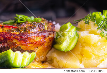 Baked meat with cheese and mashed potatoes with fresh vegetables as a side dish 135191053