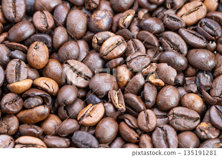 Shiny dark roast coffee beans closeup, intense oil gloss and crema hints, deep brown contrast, powerful aroma impression for espresso branding and specialty shop visuals Shiny dark roast coffee beans closeup, intense oil gloss and crema hints, deep brown contrast, powerful aroma impression for espresso branding and specialty shop visuals 135191281