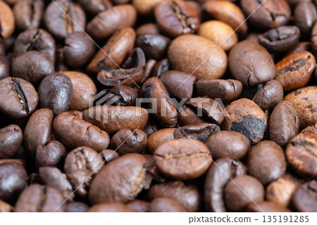 Intimate view of flavored coffee beans with warm rustic lighting, Magnified image capturing fragrant roasted coffee beans with star anise and varied shades of roasting 135191285