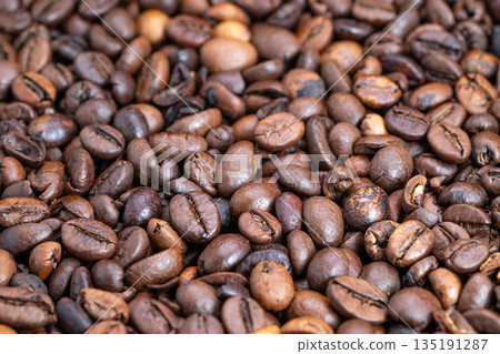 Detailed macro of roasted beans, Close perspective on shiny roasted coffee beans, High magnification photograph showcasing glossy surface of freshly roasted coffee beans Detailed macro of roasted beans, Close perspective on shiny roasted coffee beans, High magnification photograph showcasing glossy surface of freshly roasted coffee beans 135191287