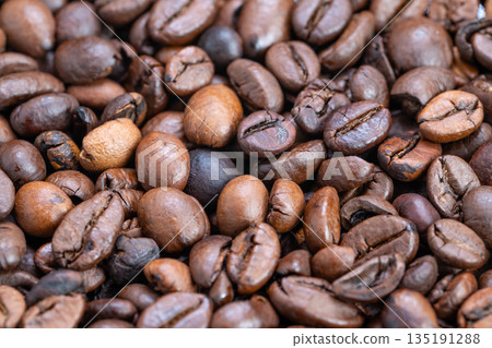 Closeup roasted coffee beans glossy texture, deep brown tones, oil sheen, scattered tight frame conveying warm aromatic mood, ideal for cafe packaging and food advertising Closeup roasted coffee beans glossy texture, deep brown tones, oil sheen, scattered tight frame conveying warm aromatic mood, ideal for cafe packaging and food advertising 135191288