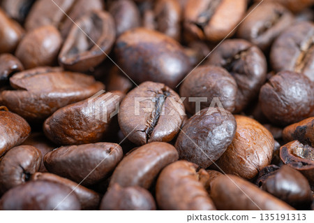 Richly roasted beans with oily sheen waiting to grind, Closeup of roasted coffee beans showcasing glossy oil layer and aromatic richness under bright studio illumination Richly roasted beans with oily sheen waiting to grind, Closeup of roasted coffee beans showcasing glossy oil layer and aromatic richness under bright studio illumination 135191313