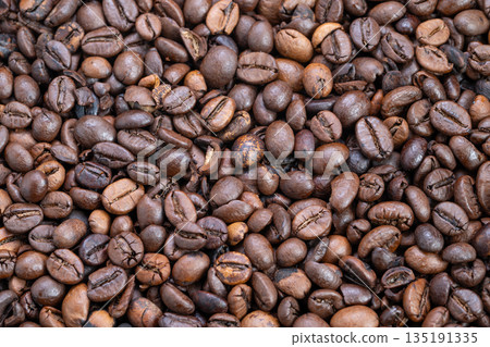 Background composed of scattered matte finish medium roast coffee beans, Abundant bulk of roasted coffee beans arranged in uniform pattern for packaging backdrop 135191335