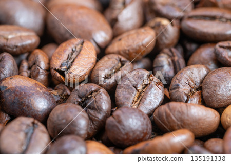 Rich roasted bean imagery, Close examination of dark roasted coffee beans with shine, Highresolution macro photograph showcasing glossy roasted coffee beans in warm lighting Rich roasted bean imagery, Close examination of dark roasted coffee beans with shine, Highresolution macro photograph showcasing glossy roasted coffee beans in warm lighting 135191338