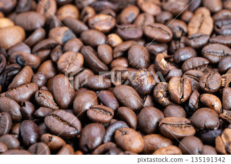 Detailed roasted coffee surface, Macro view of glossy roasted coffee beans surface, Highdetail macro shot showcasing oily roasted coffee beans with textured surface features 135191342
