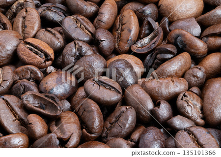 Dark brown roasted coffee with oils, Closeup of shiny roasted coffee beans showing texture, Highdetail image of glossy roasted beans highlighting texture and warm tones 135191366