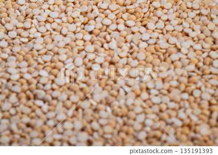 Pea grains closeup, Granular pea groats with warm natural light illumination, Close shot of beige pea groats highlighting coarse surface in warm natural kitchen setting Pea grains closeup, Granular pea groats with warm natural light illumination, Close shot of beige pea groats highlighting coarse surface in warm natural kitchen setting 135191393