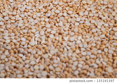 Natural textured split peas suitable for blogs, Closeup of coarse artisan split peas with warm feel, Detailed view of textured yellow split peas from handmade mill sources 135191397