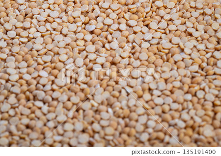 Uniform pile of yellow split peas prepared for packaging and sale, Freshly sorted yellow split peas arranged neatly in bulk for commercial distribution and purchase 135191400
