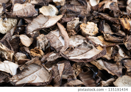 Detailed textured study dried mushroom fragments highlighting layered edges, porous surfaces and brown tonal contrast for design backgrounds and sensory projects 135191434