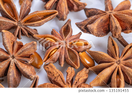 Photograph showcasing star anise pods with shiny seeds and warm tones, Aesthetic depiction of herbal star anise clusters highlighting their natural beauty and culinary appeal 135191455