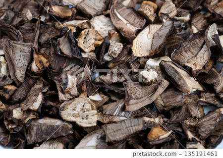 Closeup heap of dried porcini mushrooms showcasing earthy texture, curled caps, porous stems and warm brown tones, ideal for culinary blogs, chef recipes and rustic packaging Closeup heap of dried porcini mushrooms showcasing earthy texture, curled caps, porous stems and warm brown tones, ideal for culinary blogs, chef recipes and rustic packaging 135191461