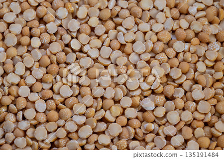 Bulk pea seed pattern texture, Industrial pea groat split arrangement background, Neutral lighting highlights detailed pattern of split pea groats for display or design Bulk pea seed pattern texture, Industrial pea groat split arrangement background, Neutral lighting highlights detailed pattern of split pea groats for display or design 135191484