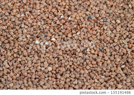 Raw buckwheat groats ready for cooking, grainy kernels showcase nutrientrich composition, neutral background, ideal for recipe content, meal prep visuals and nutrition blogs 135191486