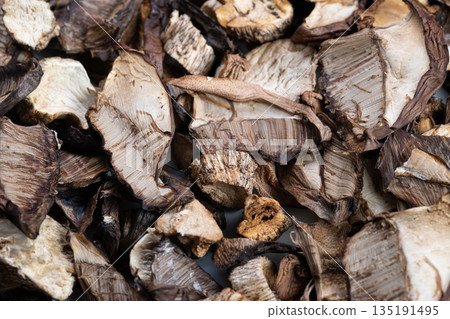 Gourmet dried mushrooms for pantry use, sliced caps and stems arranged in warm tones, conveying umami richness, artisanal ingredient ready for soups, risottos and seasonal recipes 135191495