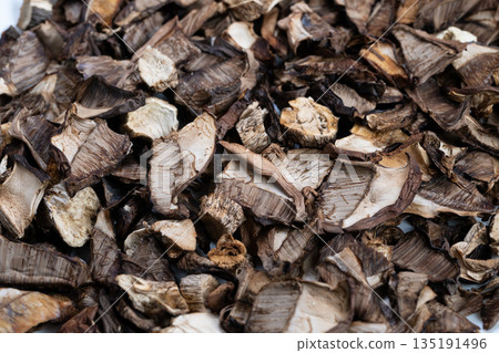 Detailed closeup of dried mushroom caps and stems with rich tones, Detailed shot capturing layered dried mushroom pieces with natural brown shades and powdery surface Detailed closeup of dried mushroom caps and stems with rich tones, Detailed shot capturing layered dried mushroom pieces with natural brown shades and powdery surface 135191496