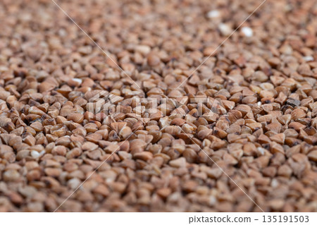 Highresolution photograph showcasing raw buckwheat with natural textures, Detailed imagery of uncooked buckwheat groats with rustic culinary elements and natural grains 135191503