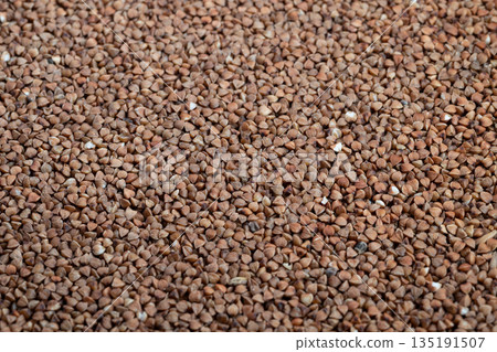 Closeup of buckwheat grains, Detailed view of dry buckwheat kernels, Presentation of buckwheat groats highlighting organic texture and artisanal baking qualities Closeup of buckwheat grains, Detailed view of dry buckwheat kernels, Presentation of buckwheat groats highlighting organic texture and artisanal baking qualities 135191507