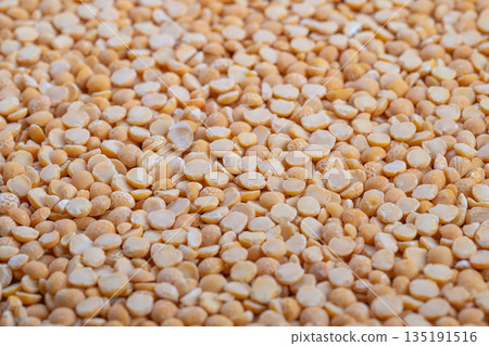Heaped split peas ready for soup, cozy kitchen mood with implied home cook stirring pot, warm lighting suggesting comfort meal, traditional recipe ingredient focus 135191516