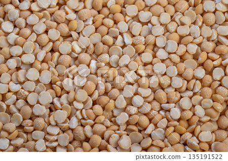 Golden legume halves on wood, Close view of warm pea groat kernels on wooden backdrop, Detailed image capturing natural light on soft textured yellow pea legume pieces Golden legume halves on wood, Close view of warm pea groat kernels on wooden backdrop, Detailed image capturing natural light on soft textured yellow pea legume pieces 135191522