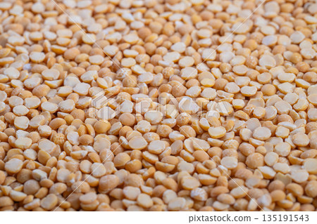 Closeup organic yellow split peas grain, evokes farmtotable sustainability and harvest inspiration, natural texture with warm daylight tones for eco messaging Closeup organic yellow split peas grain, evokes farmtotable sustainability and harvest inspiration, natural texture with warm daylight tones for eco messaging 135191543