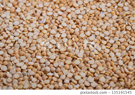 Yellow split peas in kitchen, Closeup of vibrant yellow split peas cooking, Detailed view of yellow split peas designed for comforting home cooked recipes and warm ambiance 135191545