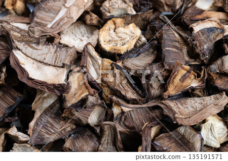 Overlapping mushroom slices with shadows, Dried mushrooms with textured surface and shadow effects, Closeup of dried mushrooms displaying contrasting shapes and tactile details 135191571
