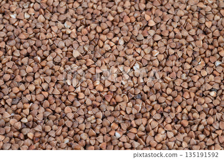 Neutraltoned buckwheat with rhythmic triangular shapes, Elegant design backdrop showcasing uniform buckwheat kernels in harmonious triangular arrangement with earthy coloring 135191592