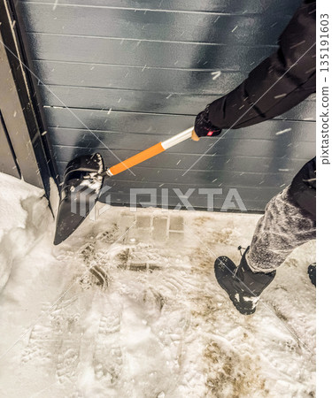 Clearing Snow from a Garage Door Clearing Snow from a Garage Door 135191603