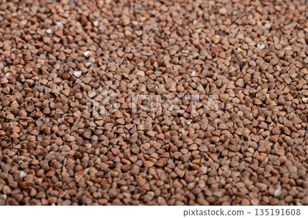 Buckwheat grains detailed, Textural image showcasing buckwheat groats texture, Highresolution closeup capturing natural appearance and tactile quality of buckwheat groats 135191608