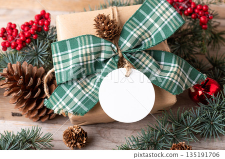 Blank round Christmas gift tag mockup with present box Blank round Christmas gift tag mockup with present box 135191706