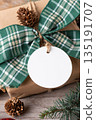 Blank round Christmas gift tag mockup with present box Blank round Christmas gift tag mockup with present box 135191707