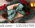 Christmas present box with green bow and natural fir branch on wooden background Christmas present box with green bow and natural fir branch on wooden background 135191709