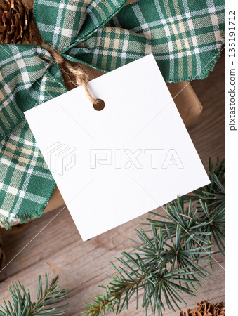 Christmas square gift tag mockup with present box on rustic background Christmas square gift tag mockup with present box on rustic background 135191712