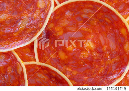 Macro chorizo pieces with cheese and oil droplets, porous texture visible, bright red color, salty aroma implied, perfect for tapas, snack boards, and closeup culinary visuals Macro chorizo pieces with cheese and oil droplets, porous texture visible, bright red color, salty aroma implied, perfect for tapas, snack boards, and closeup culinary visuals 135191749