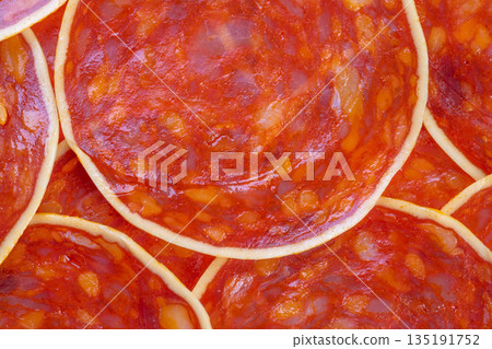 Juicy meat slices, Overlapping spicy sausage pieces, Closeup of flavorful sausage slices with rich textures, Detailed view of chorizo pieces with oily sheen and spice granules 135191752