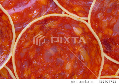 Macro culinary chorizo texture forming abstract food art, overlapping cured rings create rhythmic marbling and glossy highlights for editorial and creative projects 135191753