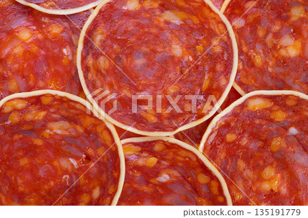 Spicy meat slices, Closeup of flavorful spicy chorizo for culinary presentation, Detailed view of vibrant red chorizo slices enriched with spices and oils for food photography 135191779