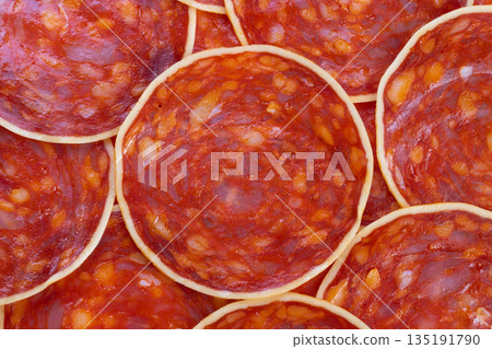 Macro shot featuring overlapping sausage slices with rich marbling, Upclose photograph showcasing layered chorizo pieces with vivid color and appealing fat details for marketing Macro shot featuring overlapping sausage slices with rich marbling, Upclose photograph showcasing layered chorizo pieces with vivid color and appealing fat details for marketing 135191790