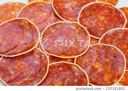 Bold food texture, Vibrant red chorizo surface, Repeating glossy chorizo slices with white highlights, Highcontrast macro pattern of vibrant red chorizo slices with white edges Bold food texture, Vibrant red chorizo surface, Repeating glossy chorizo slices with white highlights, Highcontrast macro pattern of vibrant red chorizo slices with white edges 135191802