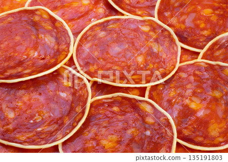 Vivid red meat with seasoning, Overlay of flavorful chorizo and cheese on wooden platter, Closeup of marbled chorizo and cheese slices arranged on warm wooden serving board Vivid red meat with seasoning, Overlay of flavorful chorizo and cheese on wooden platter, Closeup of marbled chorizo and cheese slices arranged on warm wooden serving board 135191803