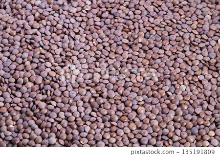 Closeup brown lentil cereal granules revealing warm earthy texture, smallbatch artisan mood, soft natural light, ideal for healthy breakfast branding and recipe imagery 135191809
