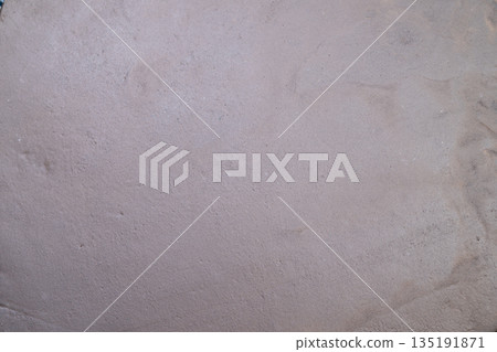 Detailed dry earth surface, Closeup of soil showing dry surface with gentle coloring hues, Magnified view revealing subtle nuances and textures of arid earth surfaces 135191871