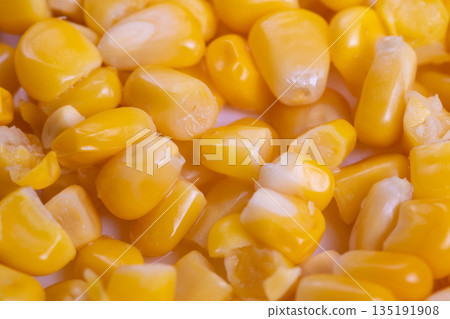 Fresh corn kernels closeup harvested from field, sunkissed yellow grains showing natural moisture and irregular shapes, rustic farm atmosphere suggested by warm tones Fresh corn kernels closeup harvested from field, sunkissed yellow grains showing natural moisture and irregular shapes, rustic farm atmosphere suggested by warm tones 135191908