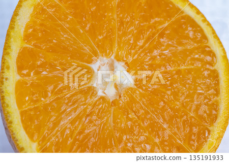 Juicy orange slice with sparkling pulp, Closeup of vibrant orange segment showing glowing flesh, Detailed closeup capturing lively colors and textures of juicy orange Juicy orange slice with sparkling pulp, Closeup of vibrant orange segment showing glowing flesh, Detailed closeup capturing lively colors and textures of juicy orange 135191933